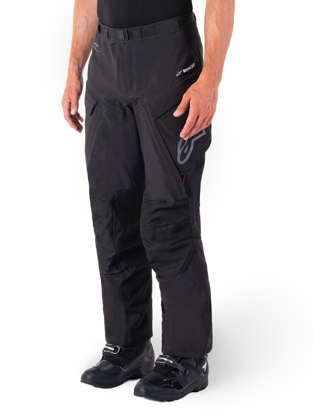 Alpinestars Hyde XT Drystar® bukser, Adventure Touring motorcykelbukser, sorte, vist med sorte støvler, med lamineret Drystar®XF-membran-branding, forstærkede knæpaneler og cargolommer med lynlås.