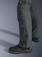 Alpinestars Borrego Drystar® bukser, antracitgrå adventure motorcykelbukser med et udseende som vokset lærred, tekstilkonstruktion vist fra siden med sorte kørestøvler, robust design til landevejs- og adventure-touring