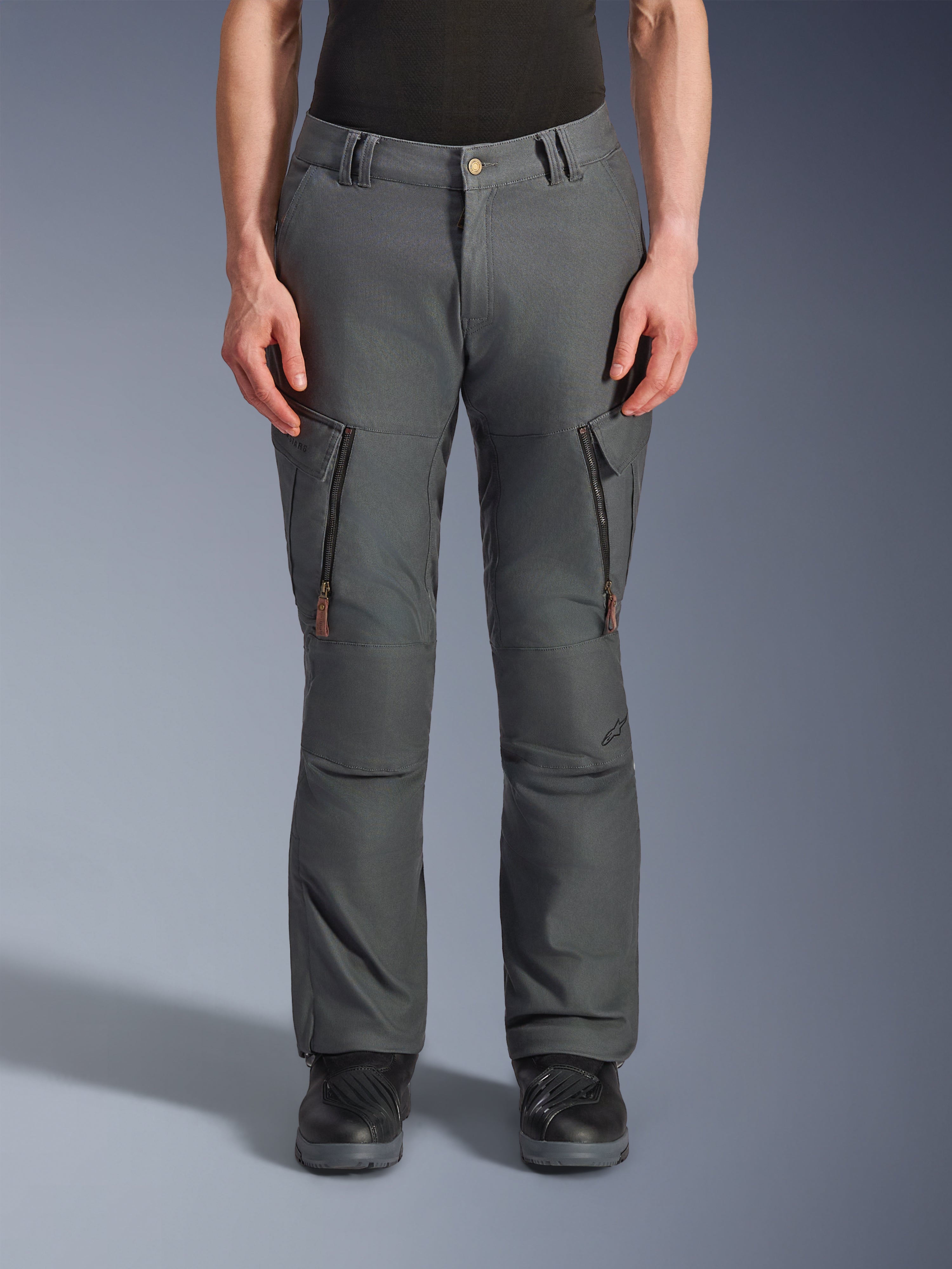 Alpinestars Borrego Drystar® bukser, adventure-motorcykelbukser, antracitgrå, med lodrette lynlåslommer på lårene med læderstropper, knaplukning i taljen og bæltestropper, båret af en model med sorte motorcykelstøvler