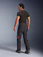 Alpinestars Halo Pro Drystar® XF laminerede bukser, Black Dark Shadow med røde detaljer, set bagfra på mandlig model, kombineret med et sort baselayer og motorcykelstøvler, teknisk adventure-touringudstyr til kørsel i alt terræn
