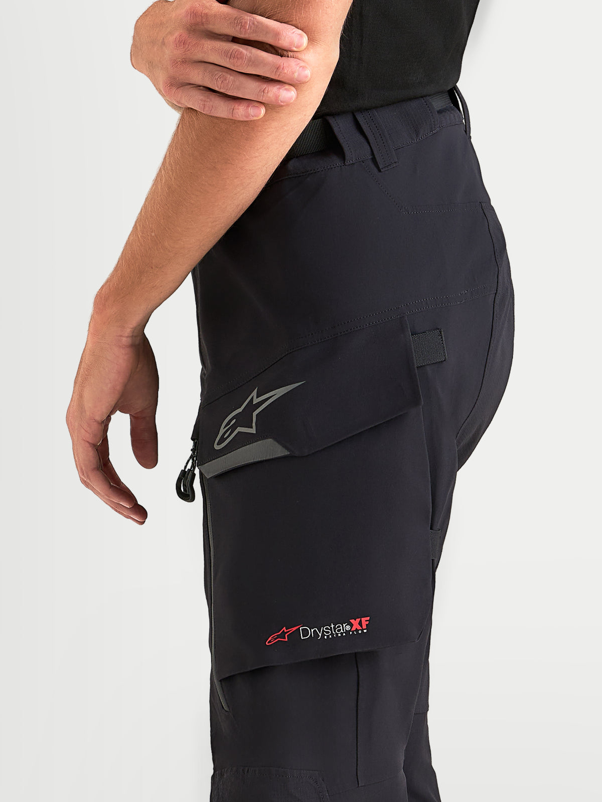 Alpinestars Maxdura Drystar XF laminerede bukser, herre adventure-motorcykelbukser i sort, med vandtæt cargolomme med reflekterende Astar-logo og Drystar XF-branding, båret af mandlig model