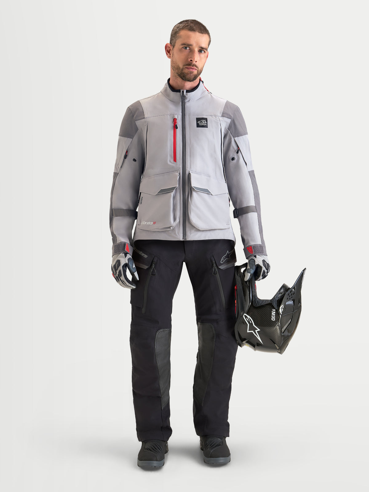 SKIP - Non-product image (reason: image shows a model wearing a complete outfit including a jacket and holding a helmet, not focused exclusively on the product pants)