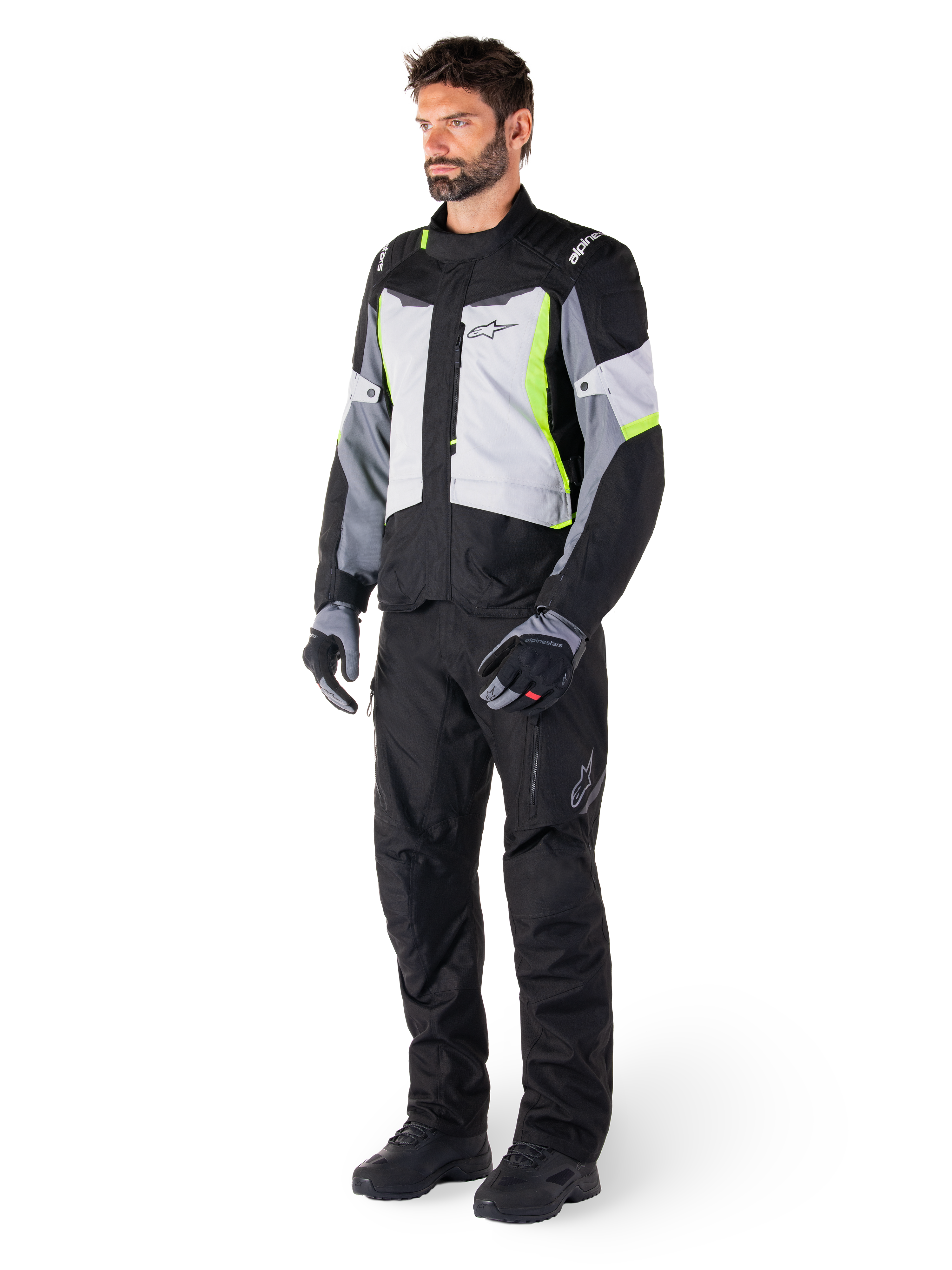 Alpinestars ST-1 Waterproof Pants, Black, worn by a male model with a grey and neon yellow touring jacket, black gloves and boots, featuring a textile design with the Alpinestars logo on the thigh, designed for all-weather adventure touring