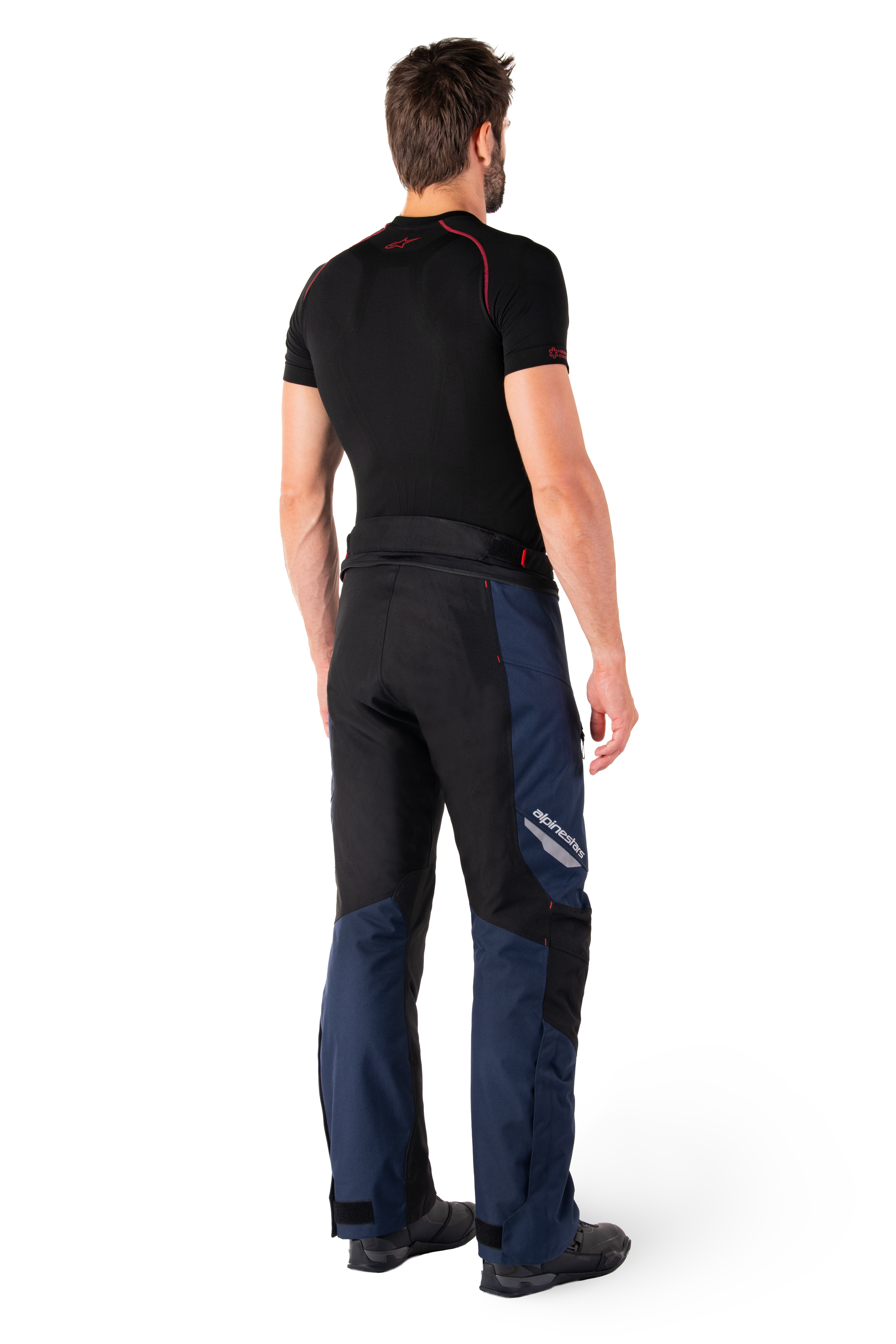 Alpinestars St-1 Waterproof Pants, Adventure Touring Pants, Dark Blue Black and Bright Red, rear side view worn with a black short-sleeved base layer and black riding boots, featuring a streamlined design with reflective branding and red accents