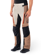 Alpinestars ST-1 Waterproof Pants, Adventure Touring Pants, Dark Khaki Sand Black and Red Fluo, featuring zippered front pockets and black reinforced panels on the knees and inner legs, worn with black riding shoes, ergonomic textile design for all-weather riding