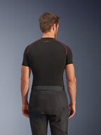 Alpinestars Cusco Drystar® bukser, sorte motorcykelbukser, set bagfra af kører iført adventure touring-udstyr med en sort kortærmet komprimeringstop med røde syninger, slidstærk ripstop og 600D-stofkonstruktion.