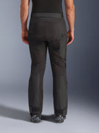 Alpinestars Cusco Drystar® bukser, motorcykelbukser, sort, set bagfra båret af en kører, med teksturerede tekstilpaneler, ventilationsåbninger med lynlås på lårene og justerbare ankellukninger, kombineret med sorte Alpinestars-støvler.
