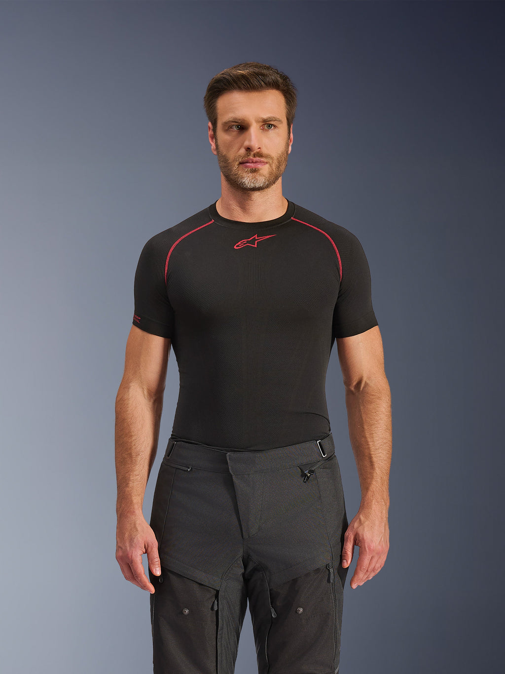 Alpinestars Cusco Drystar® bukser, adventure motorcykelbukser, sort, teknisk tekstilkonstruktion med lynlåsventilation og ripstop-paneler, båret af en mandlig model med en sort Alpinestars base layer-trøje for et komplet adventure-kørerlook