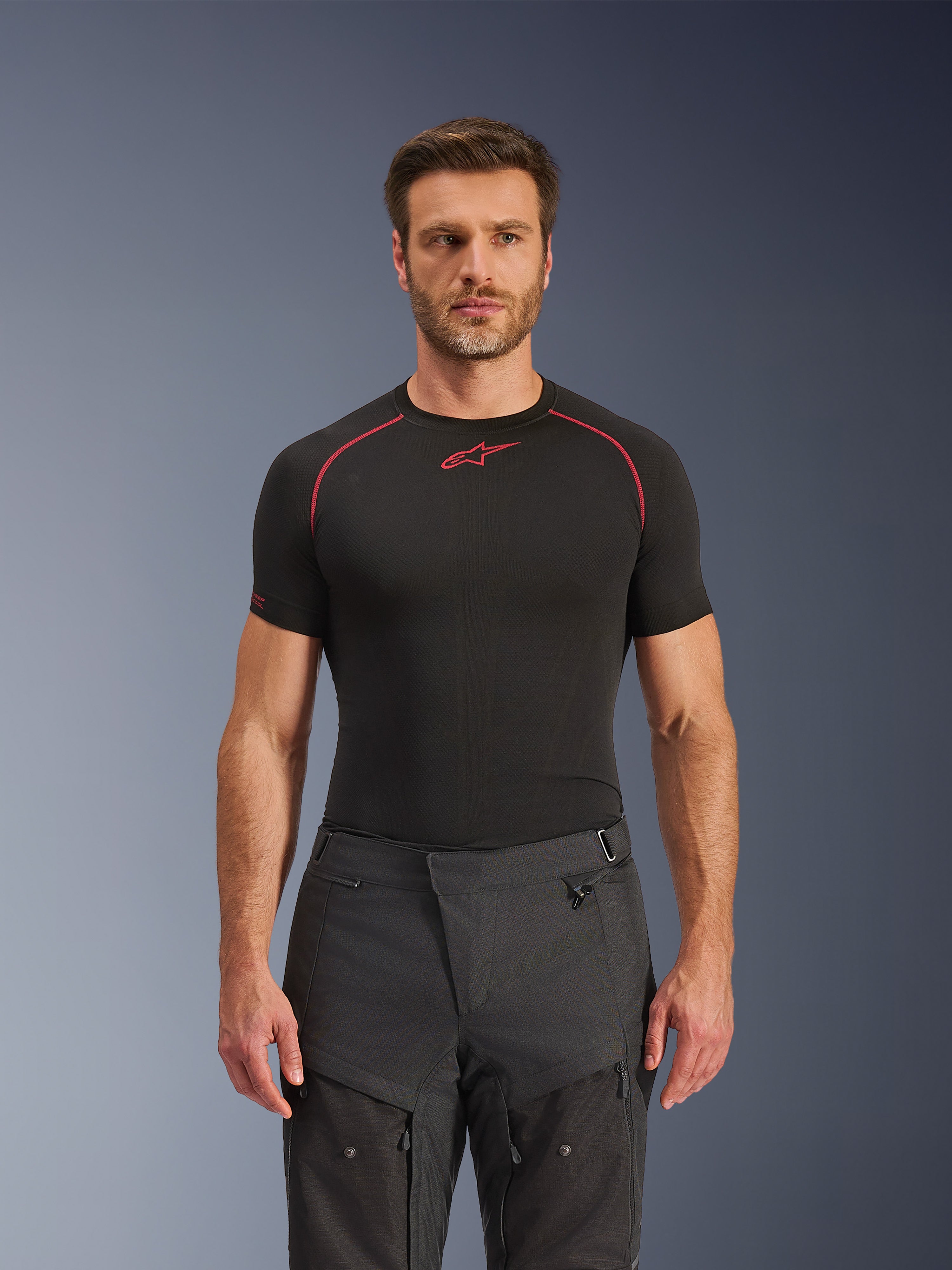 Alpinestars Cusco Drystar® bukser, adventure motorcykelbukser, sort, teknisk tekstilkonstruktion med lynlåsventilation og ripstop-paneler, båret af en mandlig model med en sort Alpinestars base layer-trøje for et komplet adventure-kørerlook