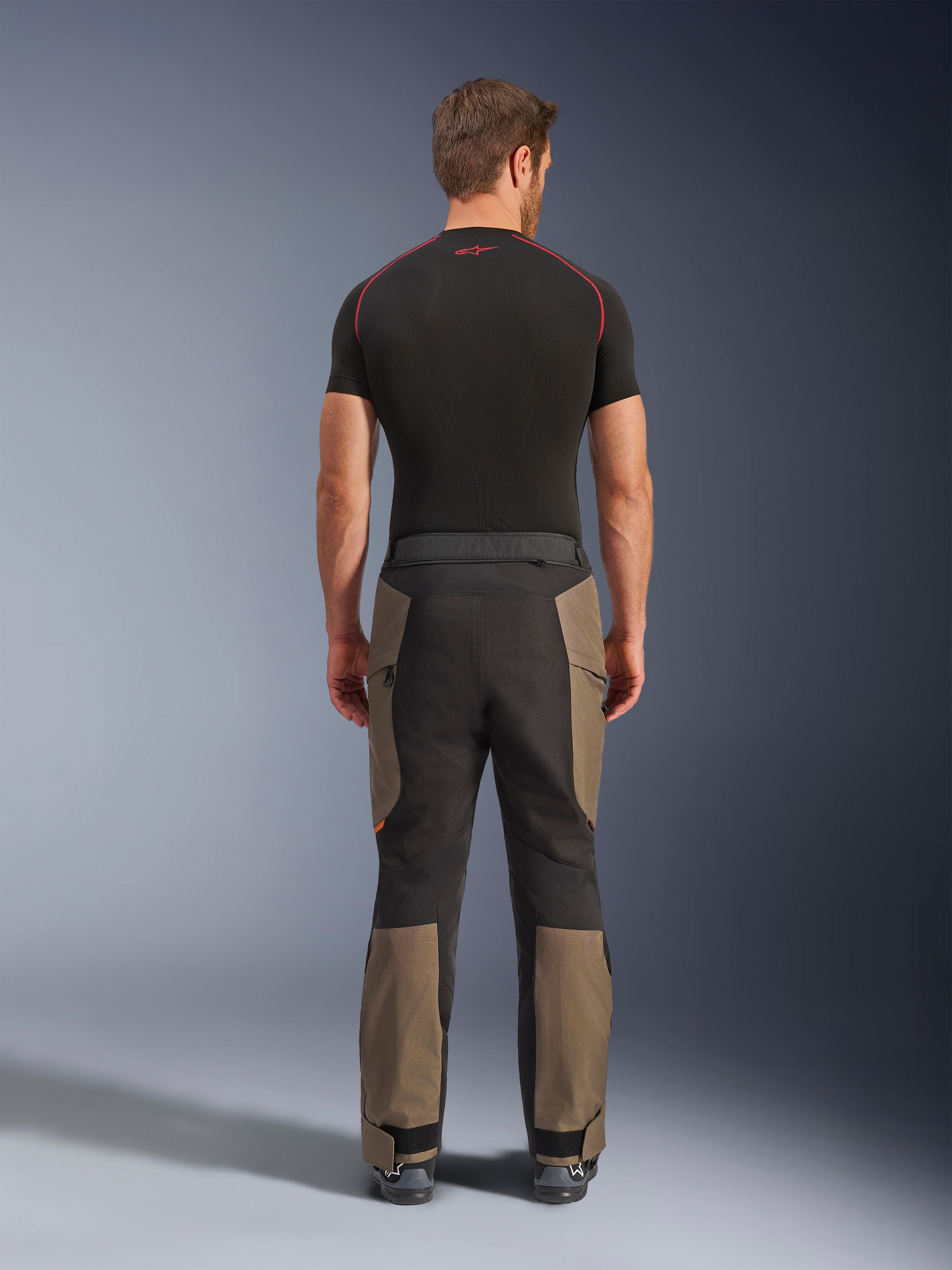 Alpinestars Cusco Drystar® bukser, adventure motorcykelbukser, Walnut Black, set bagfra med brune og sorte paneler, holdbar ripstop-konstruktion, båret med en sort base layer-trøje