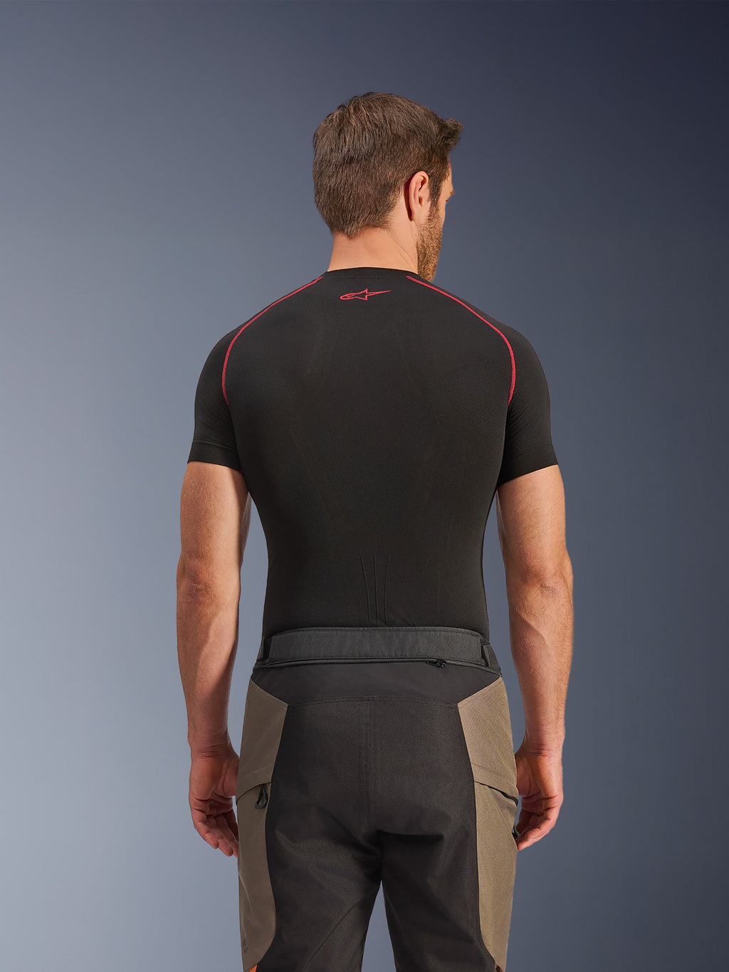 Alpinestars Cusco Drystar® bukser, adventure-kørebukser, Walnut Black, set bagfra med detaljer af taljen og farveopdelt design, båret med et sort kortærmet basislag med røde syninger og logo