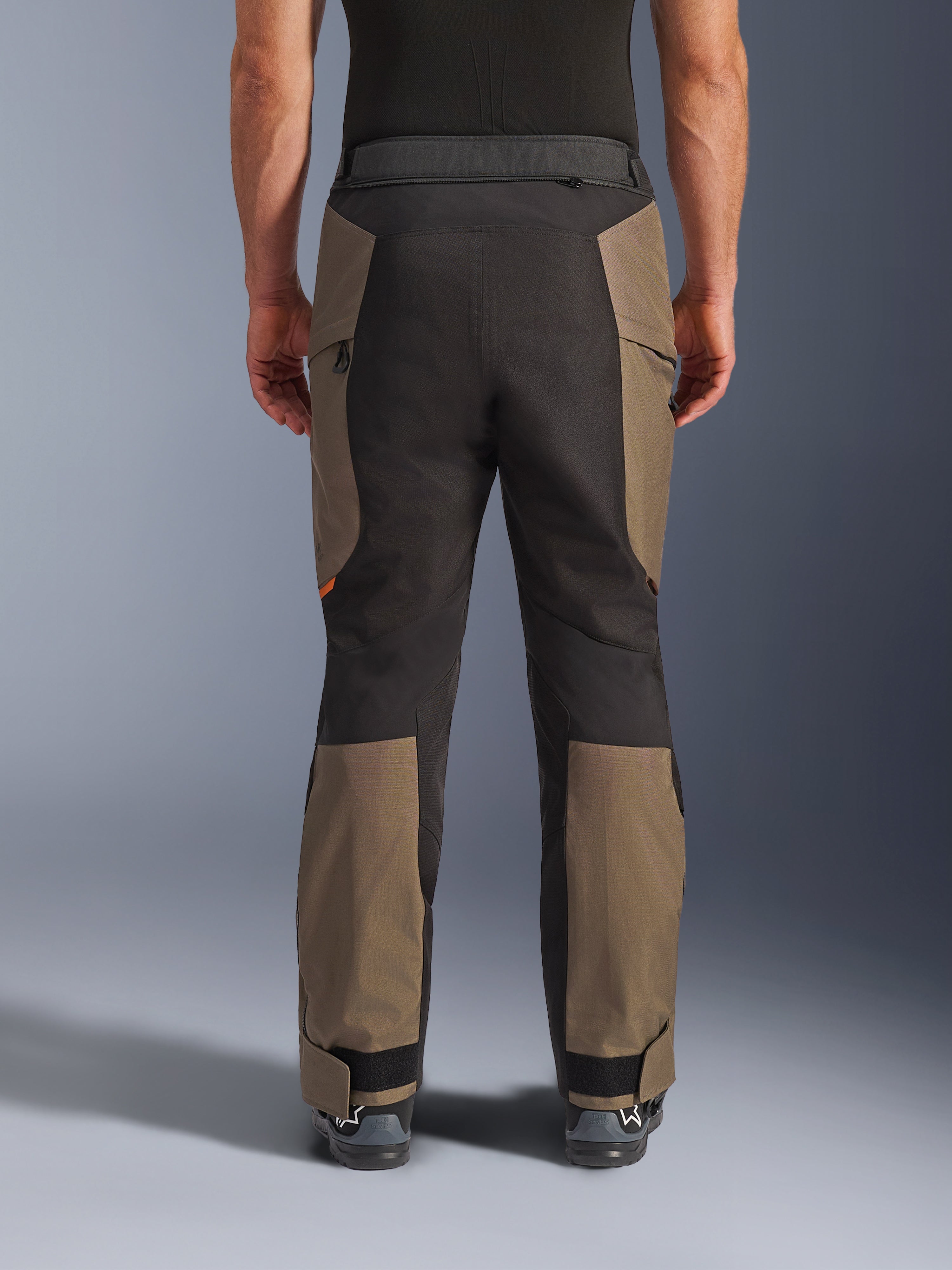 Alpinestars Cusco Drystar® bukser, adventure motorcykelbukser, Walnut Black, set bagfra på model, holdbar tekstilkonstruktion med farveblokerede paneler, justerbar kant forneden og lynlåsdetalje i taljen til touring- og adventurekørsel