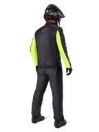 Motorcykelkører set bagfra iført Alpinestars Bogotá Pro Drystar® 3 Seasons bukser i sort, kombineret med en sort jakke med fluorescerende gule ærmer, sort adventure-hjelm og støvler, komplet adventure touring-udstyr