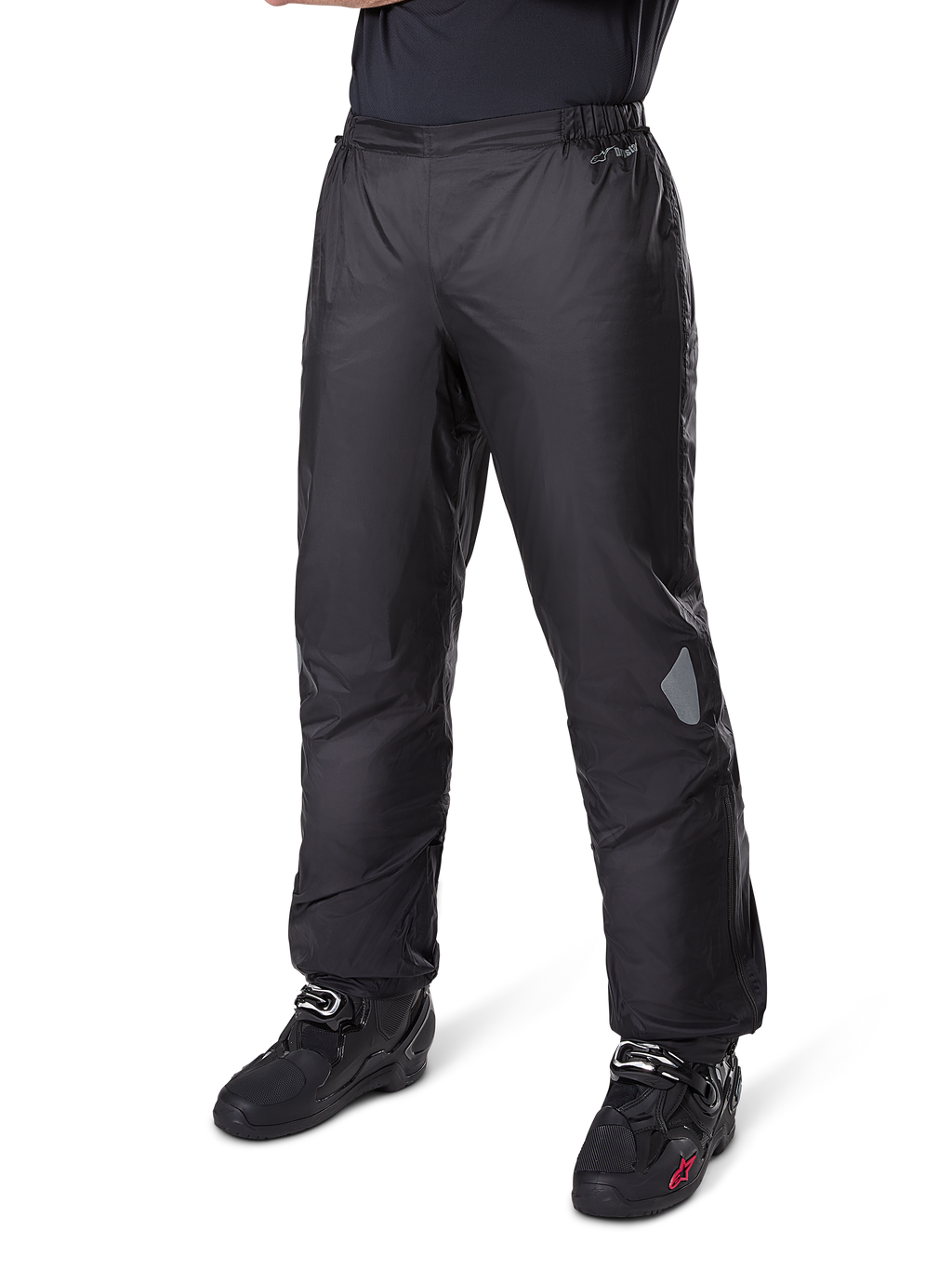 Alpinestars Bogotá Pro Drystar® 3 Seasons bukser, adventure touring motorcykelbukser, sort, båret med sorte motorcykelstøvler, med refleksfelter på knæene og Drystar-branding, letvægts vandtæt tekstildesign til helårskørsel.