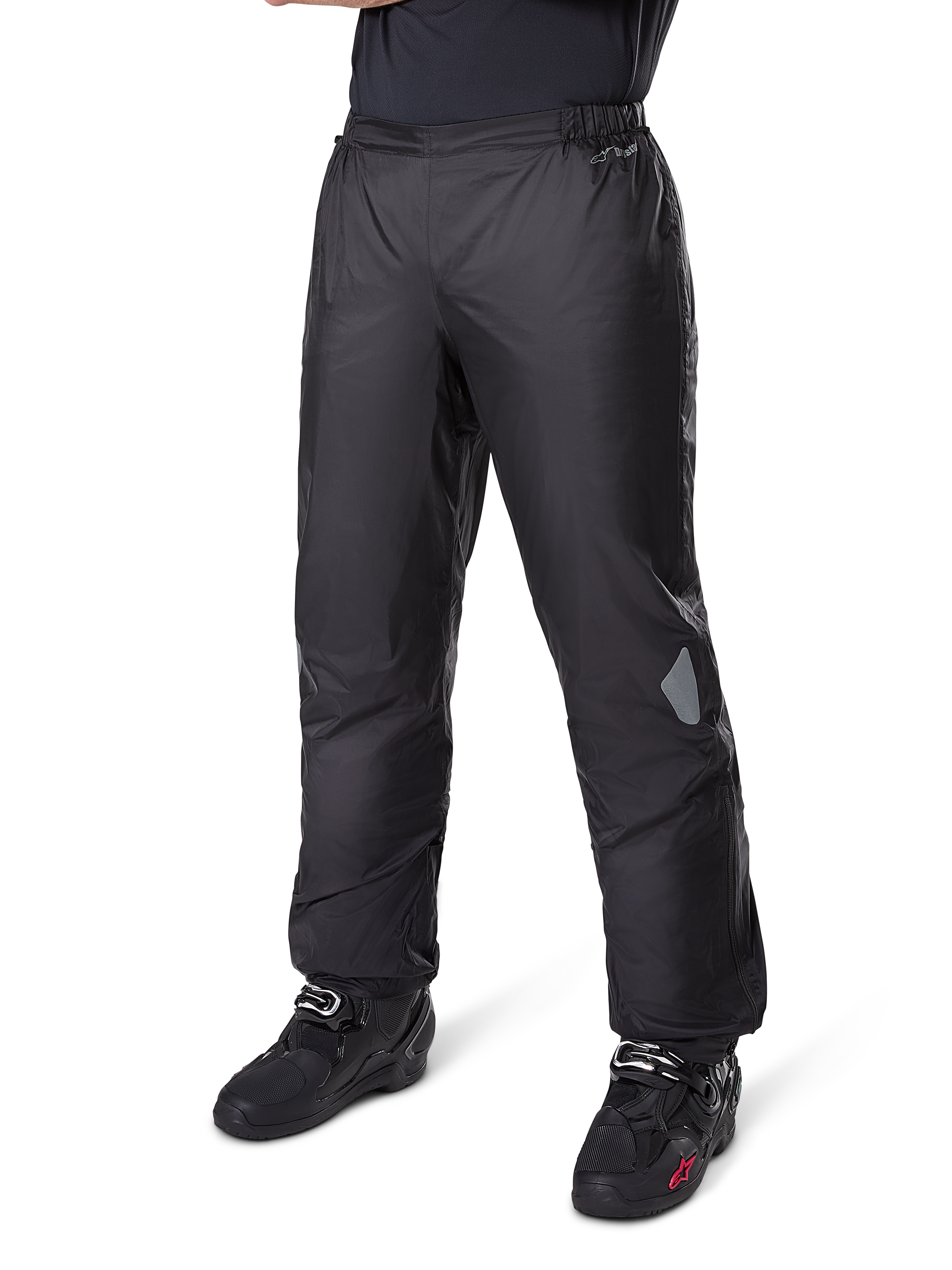 Alpinestars Bogotá Pro Drystar® 3 Seasons bukser, adventure touring motorcykelbukser, sort, båret med sorte motorcykelstøvler, med refleksfelter på knæene og Drystar-branding, letvægts vandtæt tekstildesign til helårskørsel.