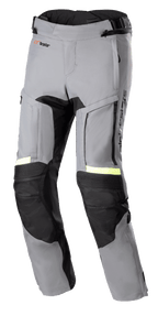 Alpinestars Bogota' Pro Drystar® 3 Seasons bukser, mørkegrå og sorte motorcykel adventure touringbukser, neongule fluorescerende refleksdetaljer, med ventilationspaneler med lynlås på lårene, harmonika-stræk ved knæene og forstærkede beskyttelsespaneler.