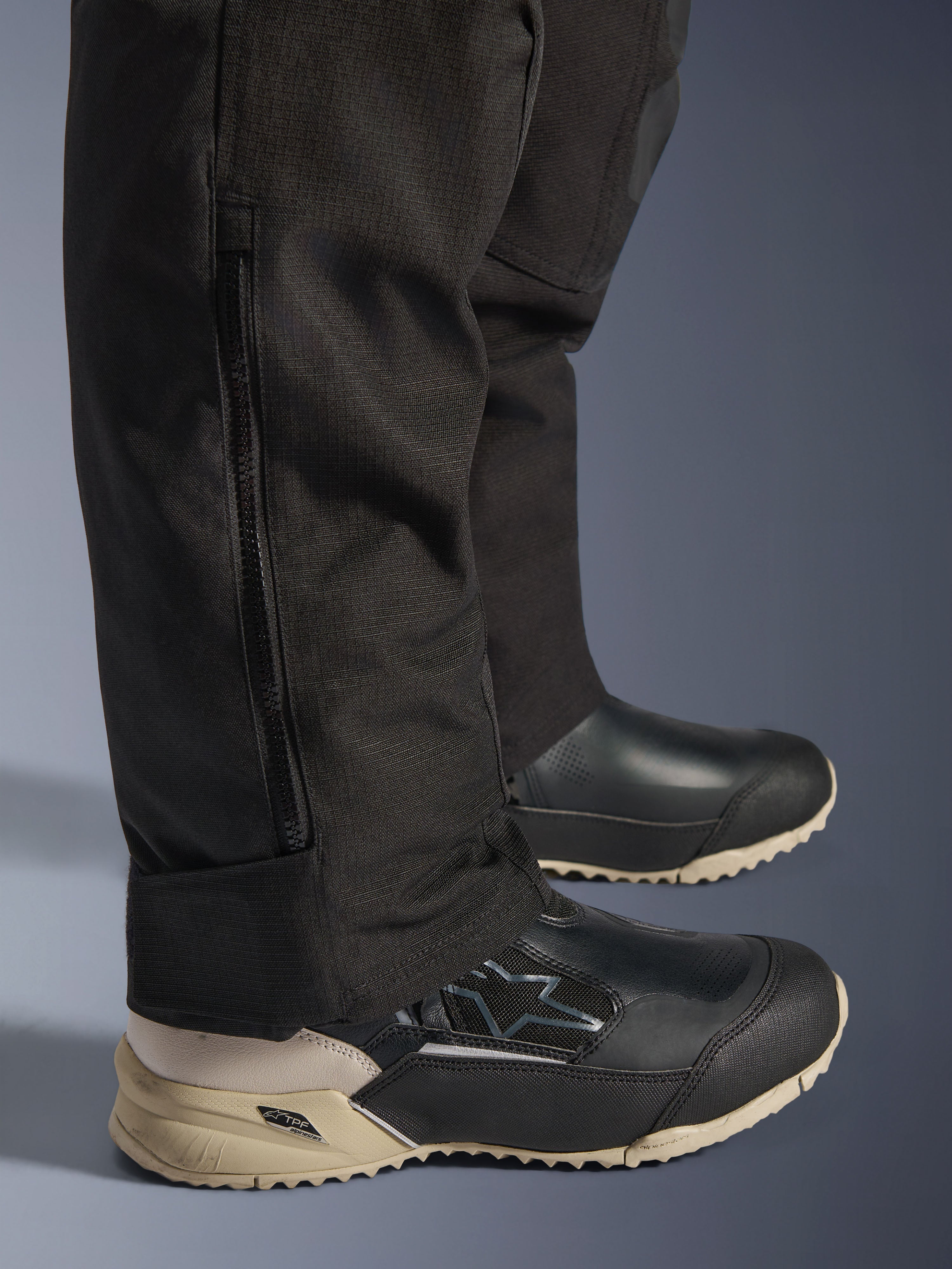 Alpinestars Stella Andes V4 Drystar® bukser, detalje af det sorte underben med lodret lynlås til pasform over støvler, slidstærk tekstilkonstruktion, adventure-motorcykeludstyr til kvinder.