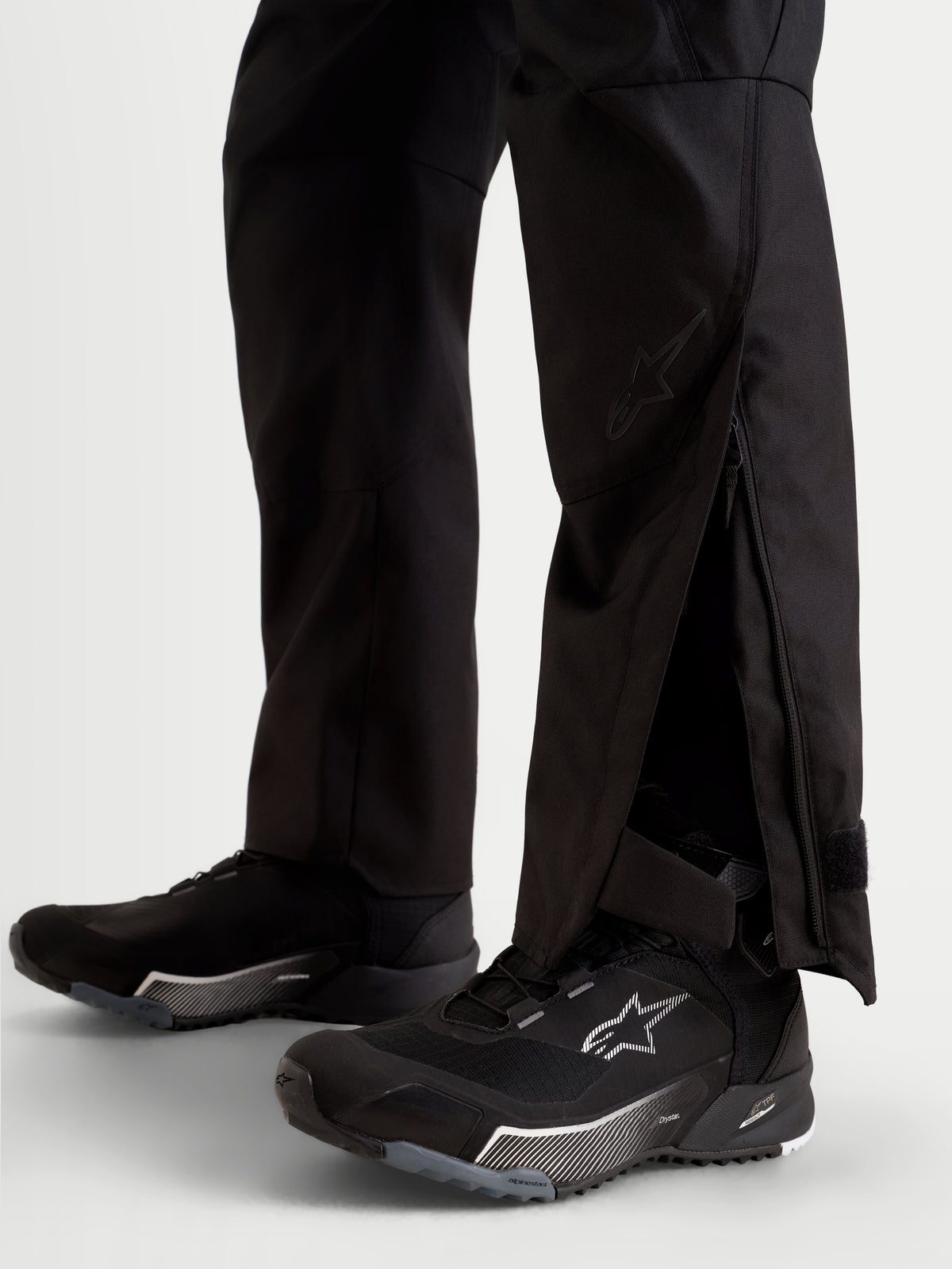 Alpinestars Stella C-1 Waterproof Bukser, damemotorcykelbukser i sort, nærbillede der viser forlængede underben med lynlåskiler båret over kørefodtøj