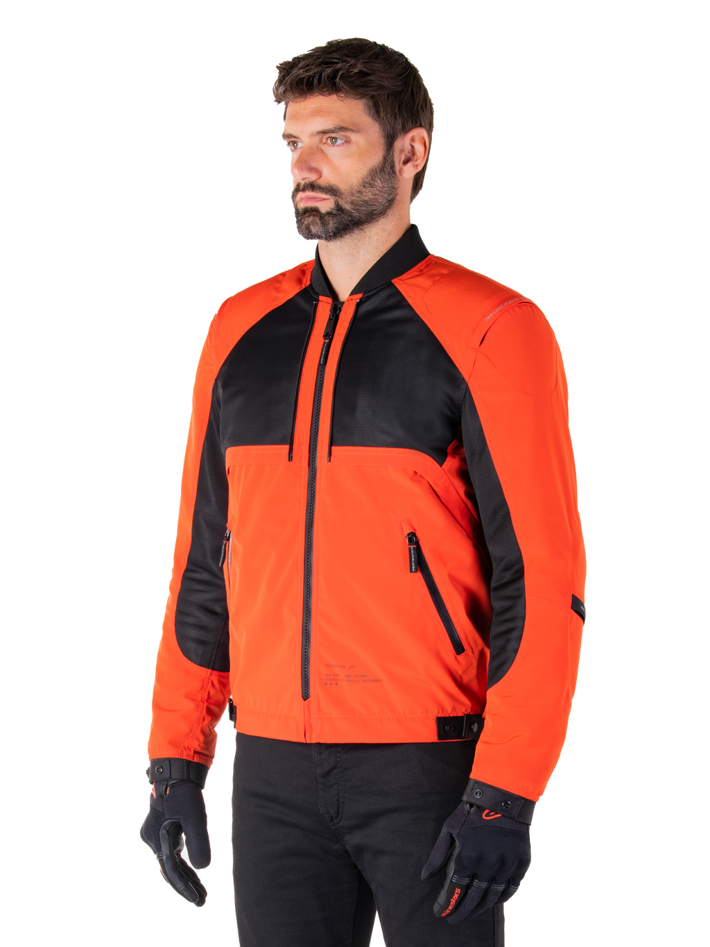 Alpinestars Mootant vandtæt parka i Spicy Orange og sort, modulær motorcykeljakke vist i sin bomber-konfiguration, med sorte mesh- og orange tekstilpaneler, urbant moderne køreudstyr båret med sorte handsker