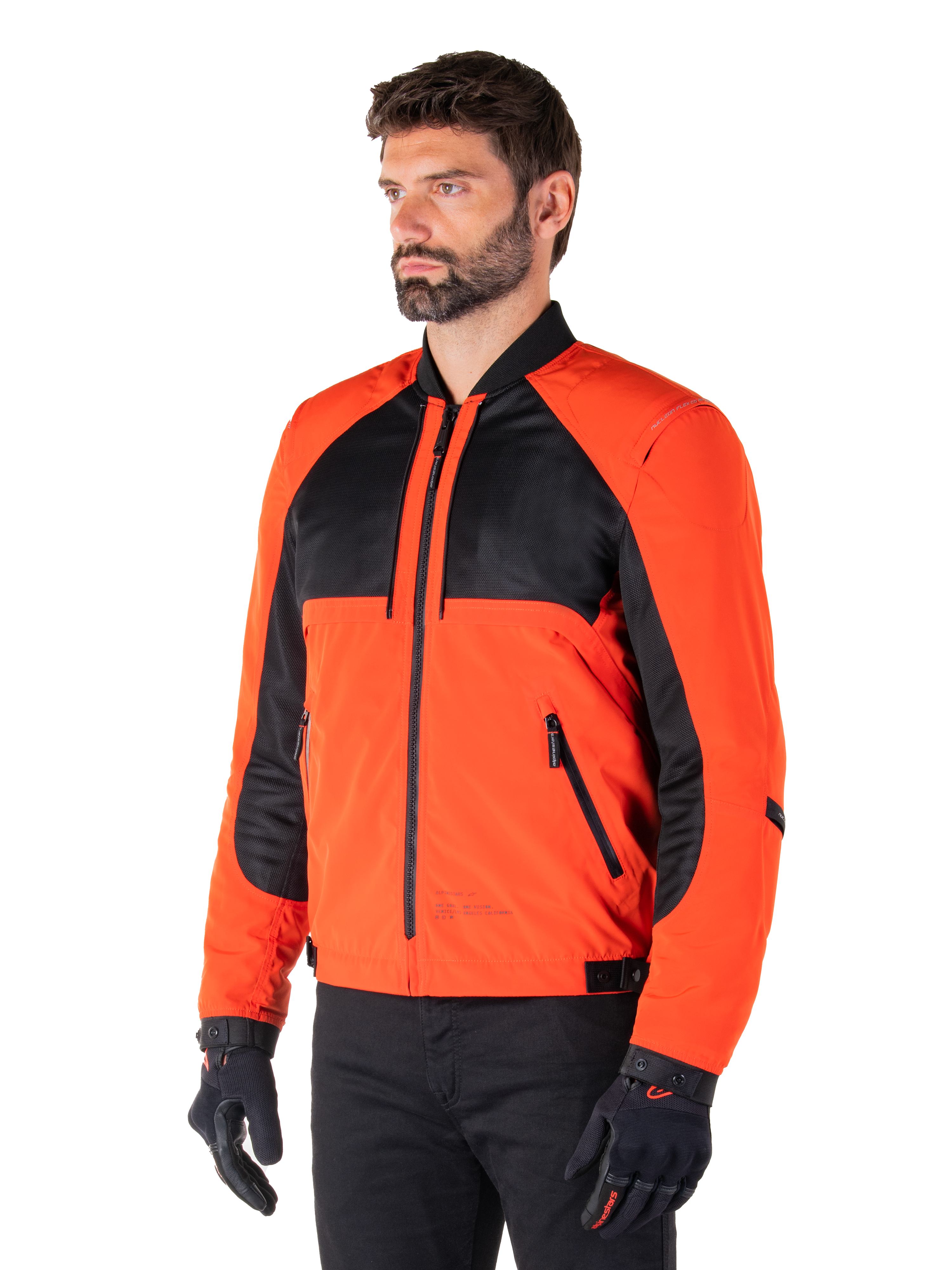 Alpinestars Mootant vandtæt parka i Spicy Orange og sort, modulær motorcykeljakke vist i sin bomber-konfiguration, med sorte mesh- og orange tekstilpaneler, urbant moderne køreudstyr båret med sorte handsker