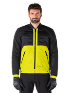 Alpinestars Mootant Waterproof Parka, modulær motorcykeljakke, Lime Punch og sort, båret af en mandlig model med sorte handsker og bukser, med en livlig gul underdel og sort overkrop og ærmer, utilitaristisk design til kørsel i alt slags vejr