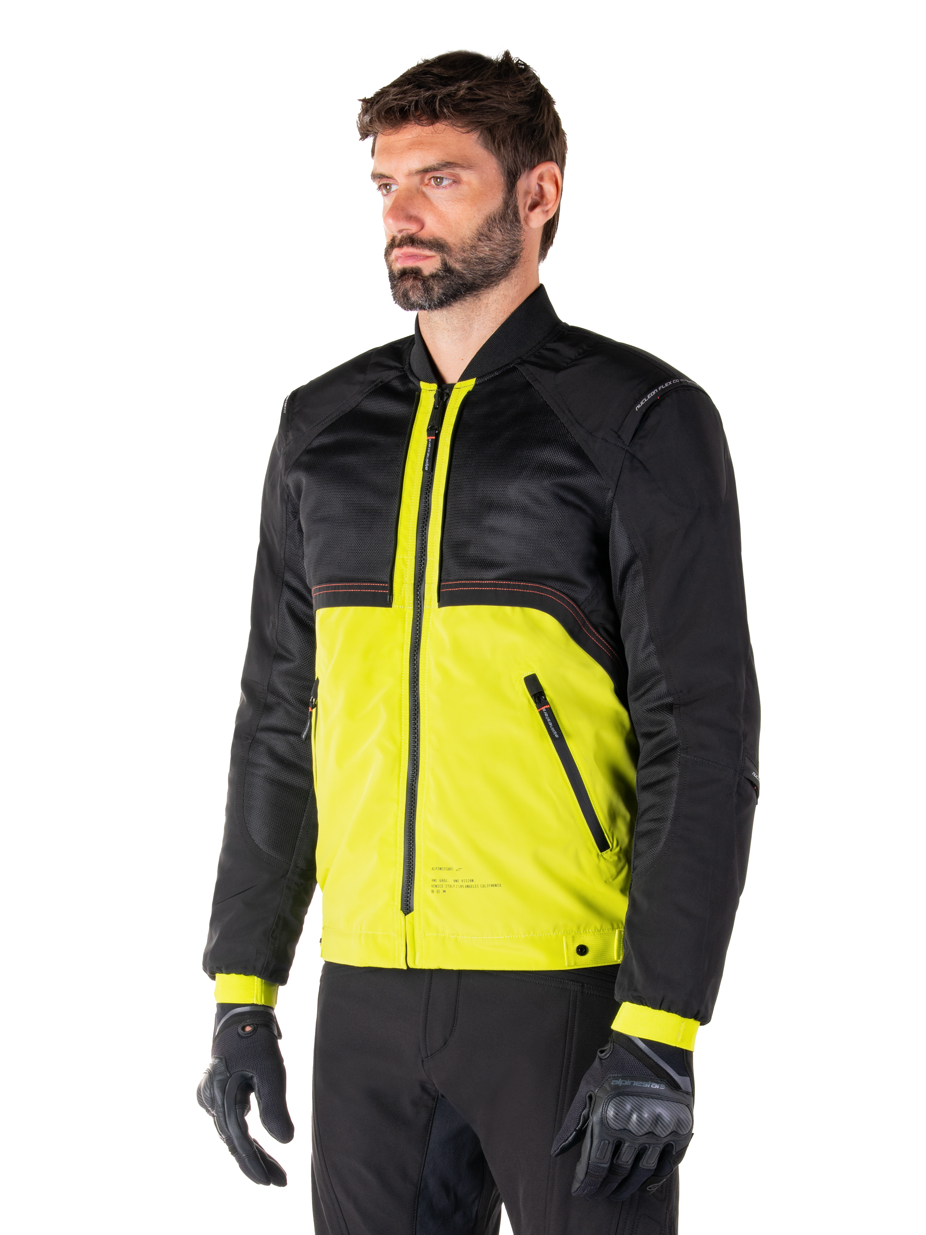 Alpinestars Mootant vandtæt parka i Lime Punch Black, modulær motorcykeljakke med sort mesh-overdel og livlig limegrøn underdel, båret af en mandlig kører med sorte handsker og bukser, moderne urban kørestil