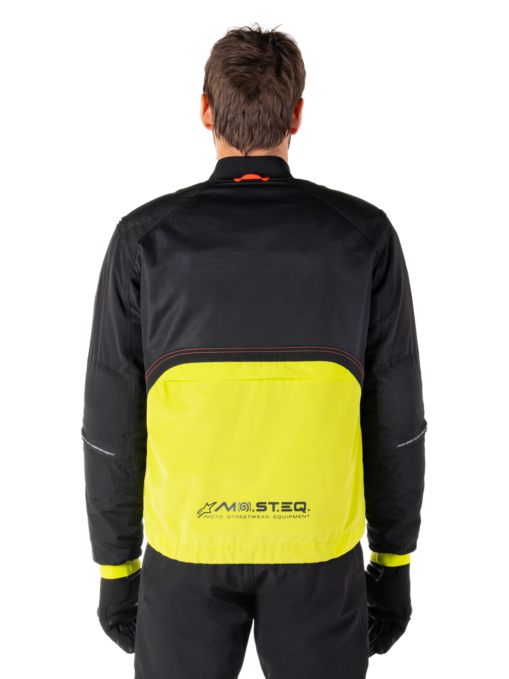 Alpinestars Mootant vandtæt parka, motorcykeljakke, Lime Punch og sort, set bagfra med sort mesh-overdel til ventilation og limefarvet underdel med MO.ST.EQ.-logo, vist med sorte bukser og handsker