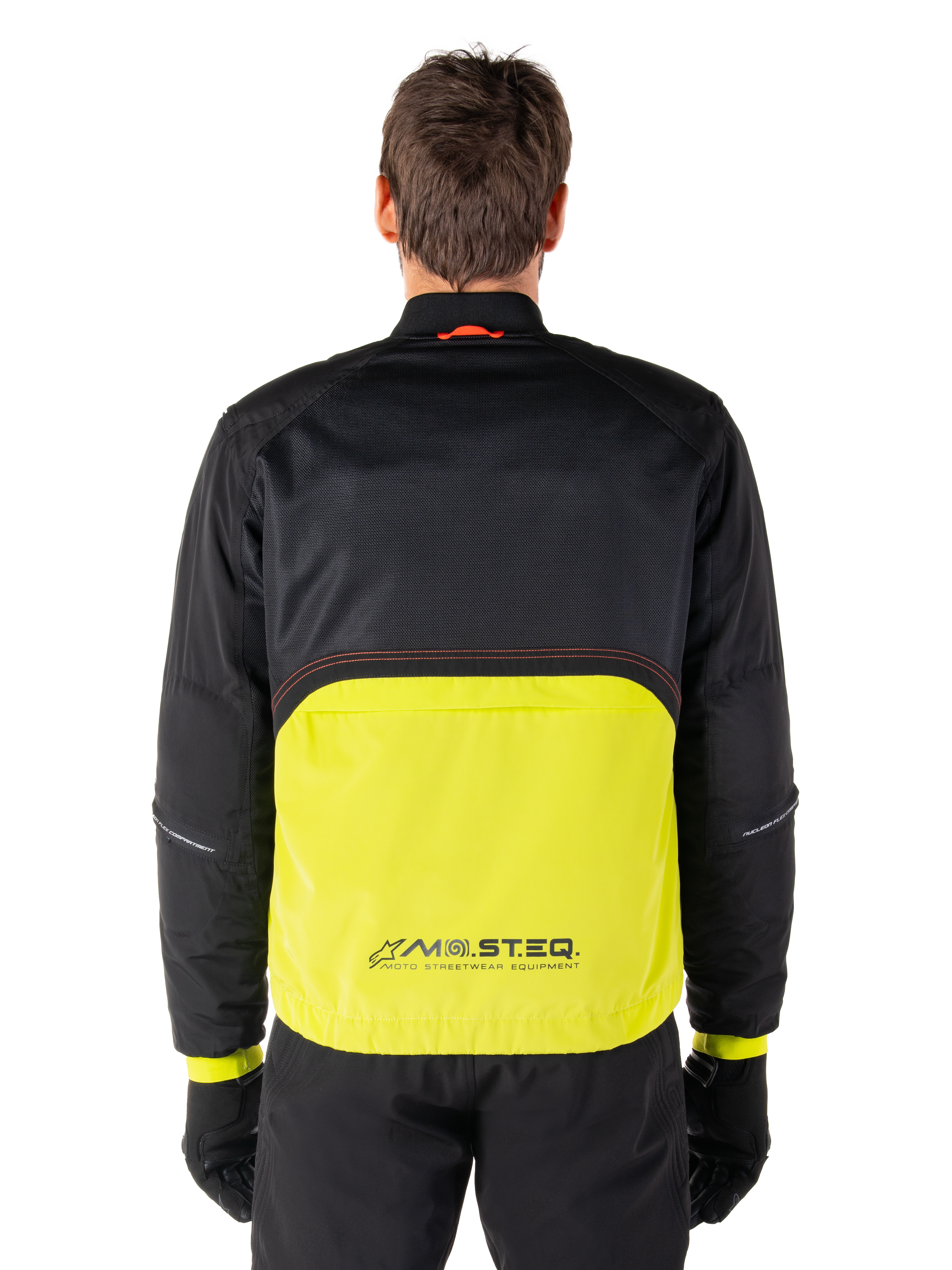 Alpinestars Mootant vandtæt parka, motorcykeljakke, Lime Punch og sort, set bagfra med sort mesh-overdel til ventilation og limefarvet underdel med MO.ST.EQ.-logo, vist med sorte bukser og handsker