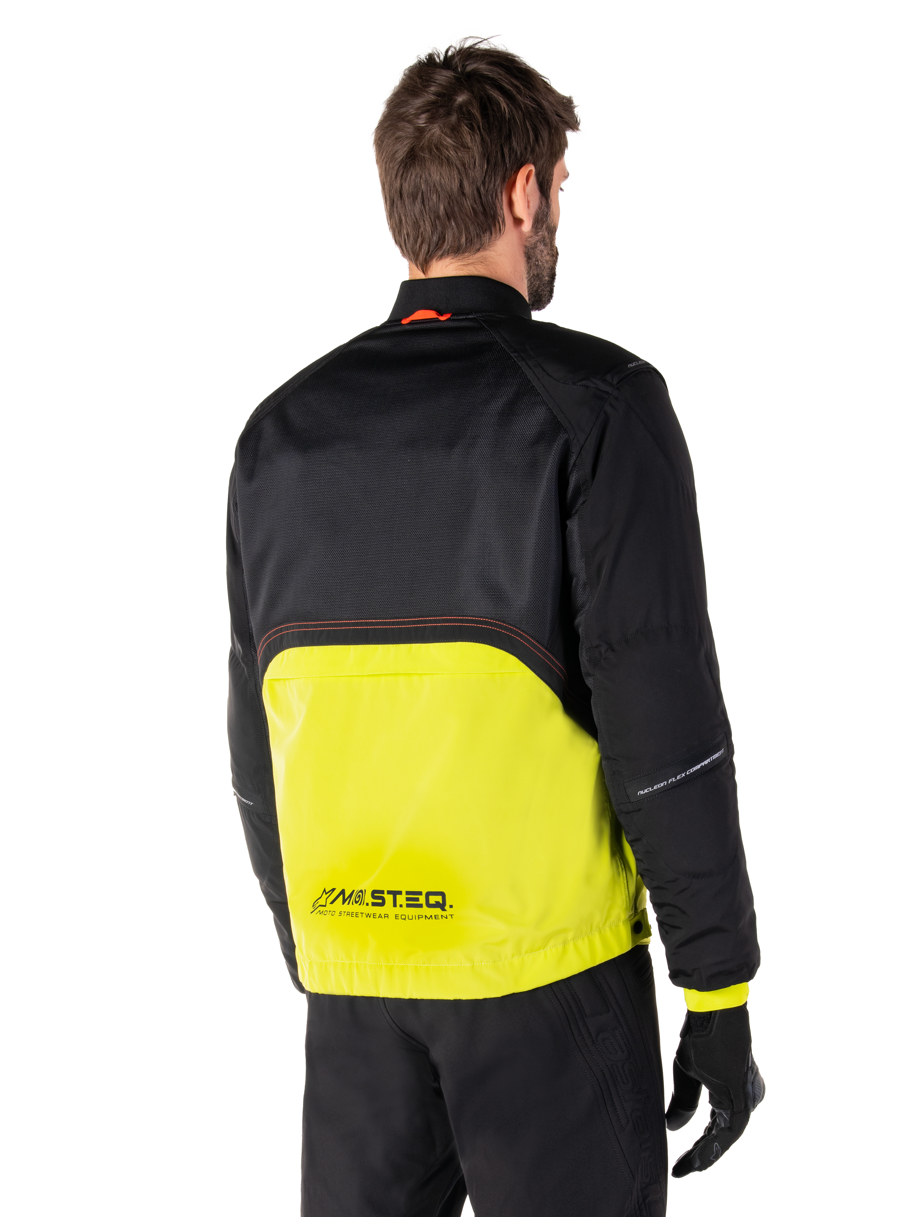 Alpinestars Mootant vandtæt parka, motorcykeljakke, Lime Punch og sort, set bagfra med sort mesh øverst og klar limegrøn underdel, MO.ST.EQ.-branding, båret med sorte motorcykelbukser og handsker