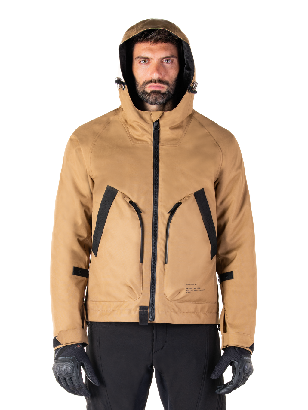 Alpinestars Morush vandtæt parka, motorcykeljakke, Utility Brown, hætteklædt streetwear-inspireret design med store frontlommer med sorte detaljer, båret med sorte kørehandsker og bukser, moderne urbant motorcykeludstyr