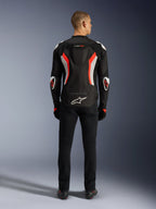 Alpinestars T-GP Air Jacket, motorcykeljakke, sort og fluoriserende rød, set bagfra på en model, med en aerodynamisk pukkel, hvide og fluoriserende røde detaljer, Alpinestars-logo nederst på ryggen, sportstilpasset design til landevejskørsel.