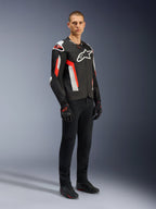 Alpinestars T-GP Air jakke, Black Red Fluo, båret af model med sorte kørebukser og handsker, med laserperforerede tekstilpaneler, hvidt Alpinestars-branding og røde accenter, sport-motorcykeljakke til landevejskørsel i varmt vejr