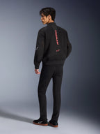 Mandlig model iført Alpinestars Flight Air-jakke i Black Bright Red, set bagfra viser lodret rød branding på ryggen og 3D-mesh-konstruktion, kombineret med sorte bukser og sneakers, urban motorcykelstil