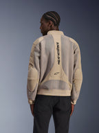 Alpinestars Flight Air-jakke, urban motorcykeljakke, tan, set bagfra med udvidede 3D-mesh-paneler og lodret Alpinestars-branding på ryggen, bomber-inspireret design med ribkant, båret af model i sorte bukser