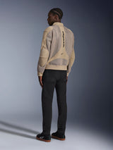 Alpinestars Flight Air-jakke, urban motorcykeljakke i tekstil, brun, set bagfra med store 3D-mesh-paneler og lodret logo, bomber-silhuet med ribstrikket krave og kant, kombineret med sorte bukser og sorte sko for en street-inspireret kørestil.