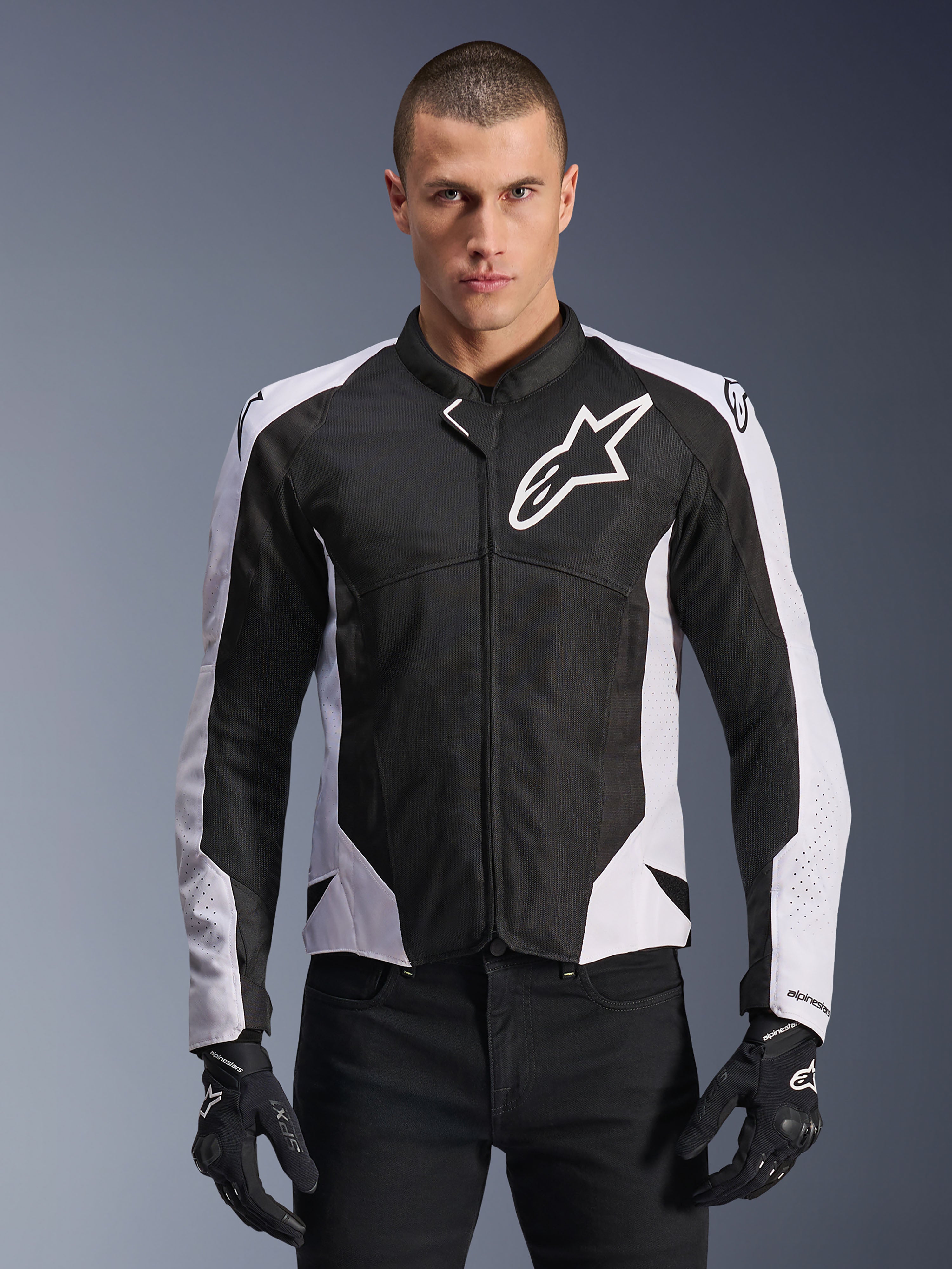 Alpinestars Viper Air V4 jakke, motorcykeljakke til racing, sort og hvid, båret af kører, teknisk mesh- og tekstilkonstruktion med hvide skulderpaneler, fremtrædende stjerne-logo på brystet, sportsligt performance-design, kombineret med sorte kørehandsker