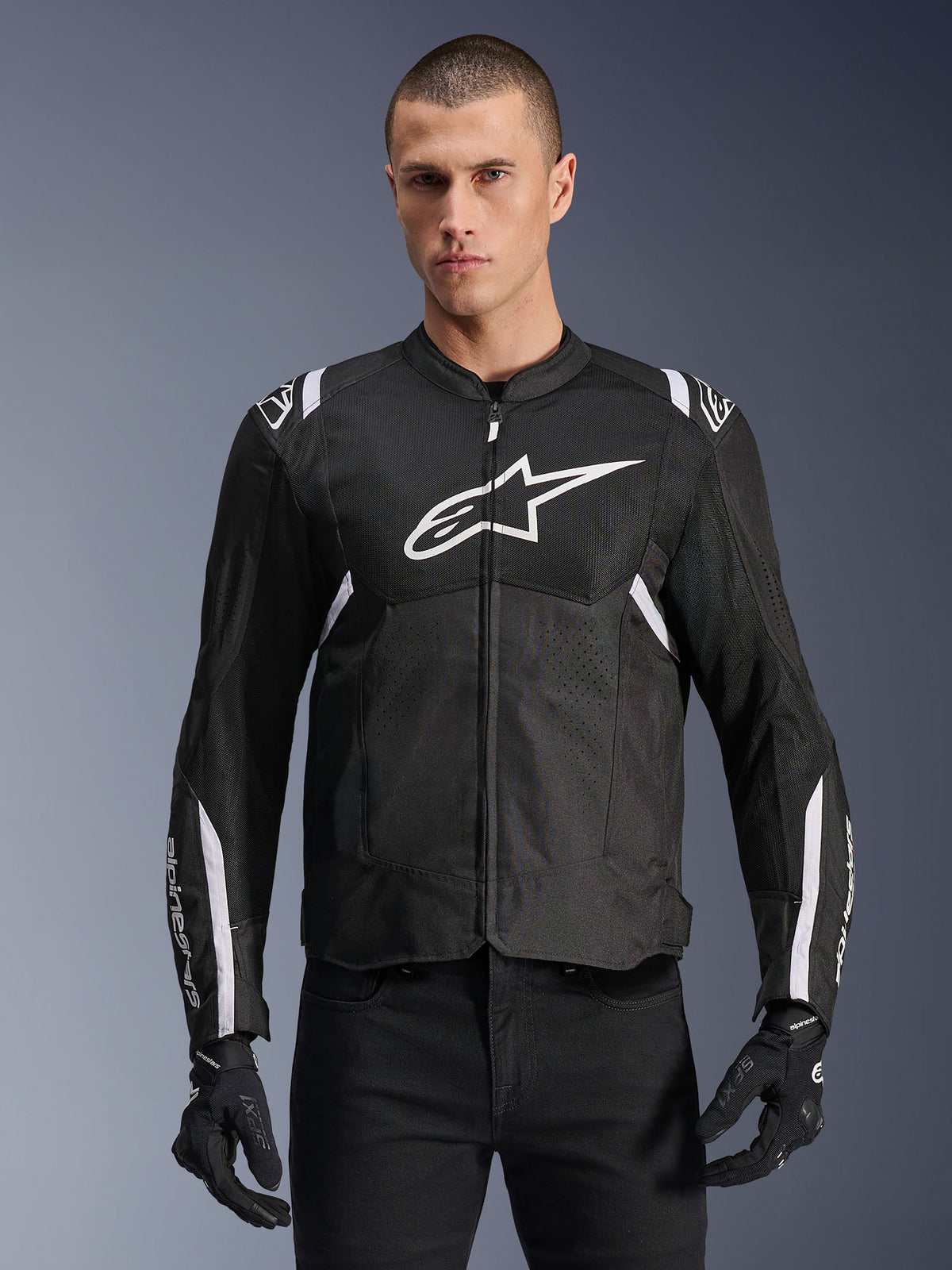 Alpinestars T-SPS Air V2 Jacket, Textile Motorcycle Jacket, Black with White Accents, large white chest logo, perforated mesh design for ventilation, worn with black pants and gloves