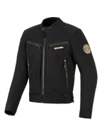 Alpinestars Bruiser-jakke, sort urban motorcykeljakke, har bryst- og håndlommer med lynlås, guldfarvet branding og Oscar spiral-mærke på skulderen, arbejdstøjsinspireret tekstildesign.