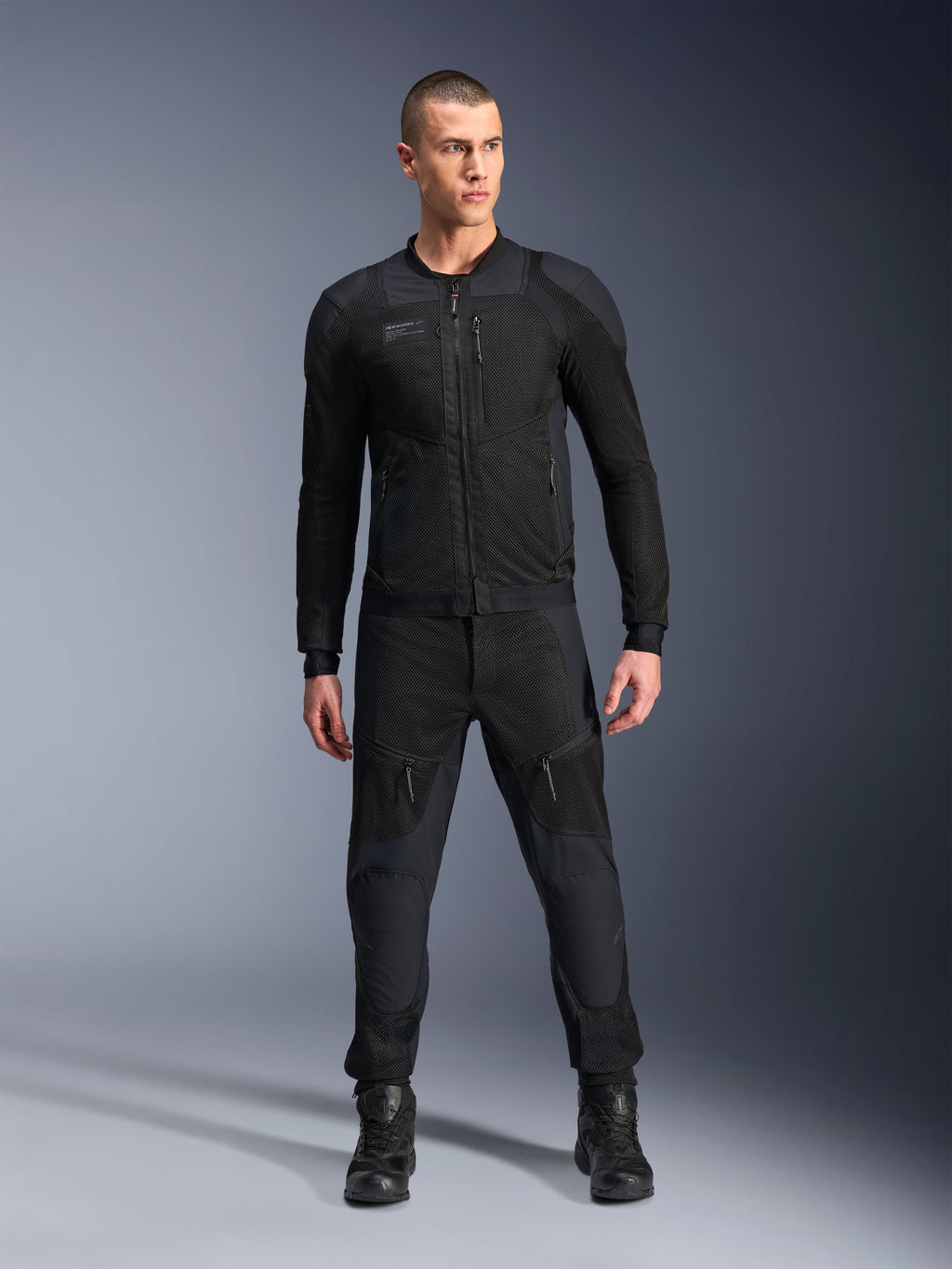 Alpinestars Troop-Air Pro Jakke, sort teknisk pansret motorcykeljakke, med mesh-paneler og lynlåse foran, båret med matchende sorte bukser og motorcykelstøvler, premium urbant køreudstyr