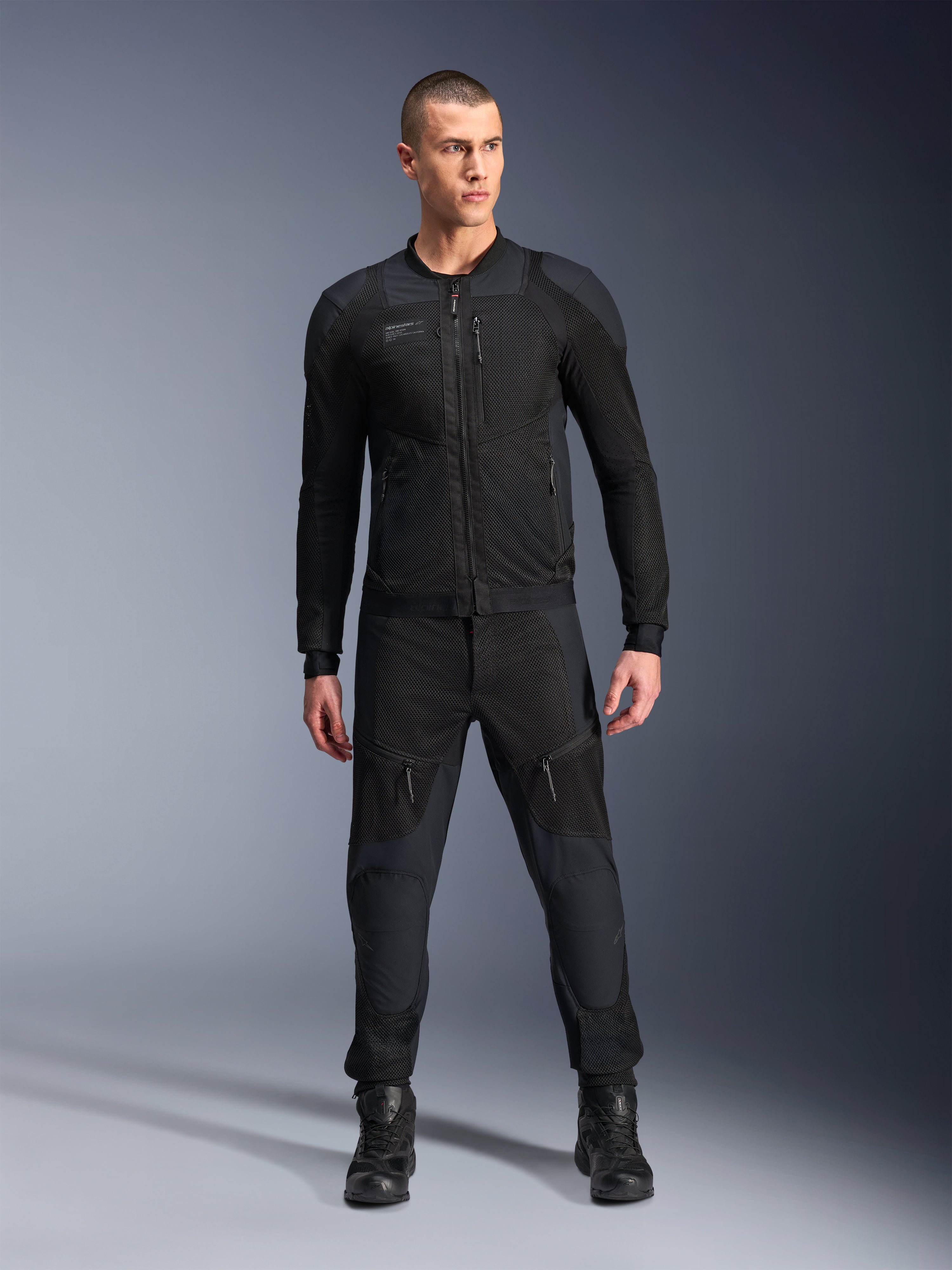 Alpinestars Troop-Air Pro Jakke, sort teknisk pansret motorcykeljakke, med mesh-paneler og lynlåse foran, båret med matchende sorte bukser og motorcykelstøvler, premium urbant køreudstyr