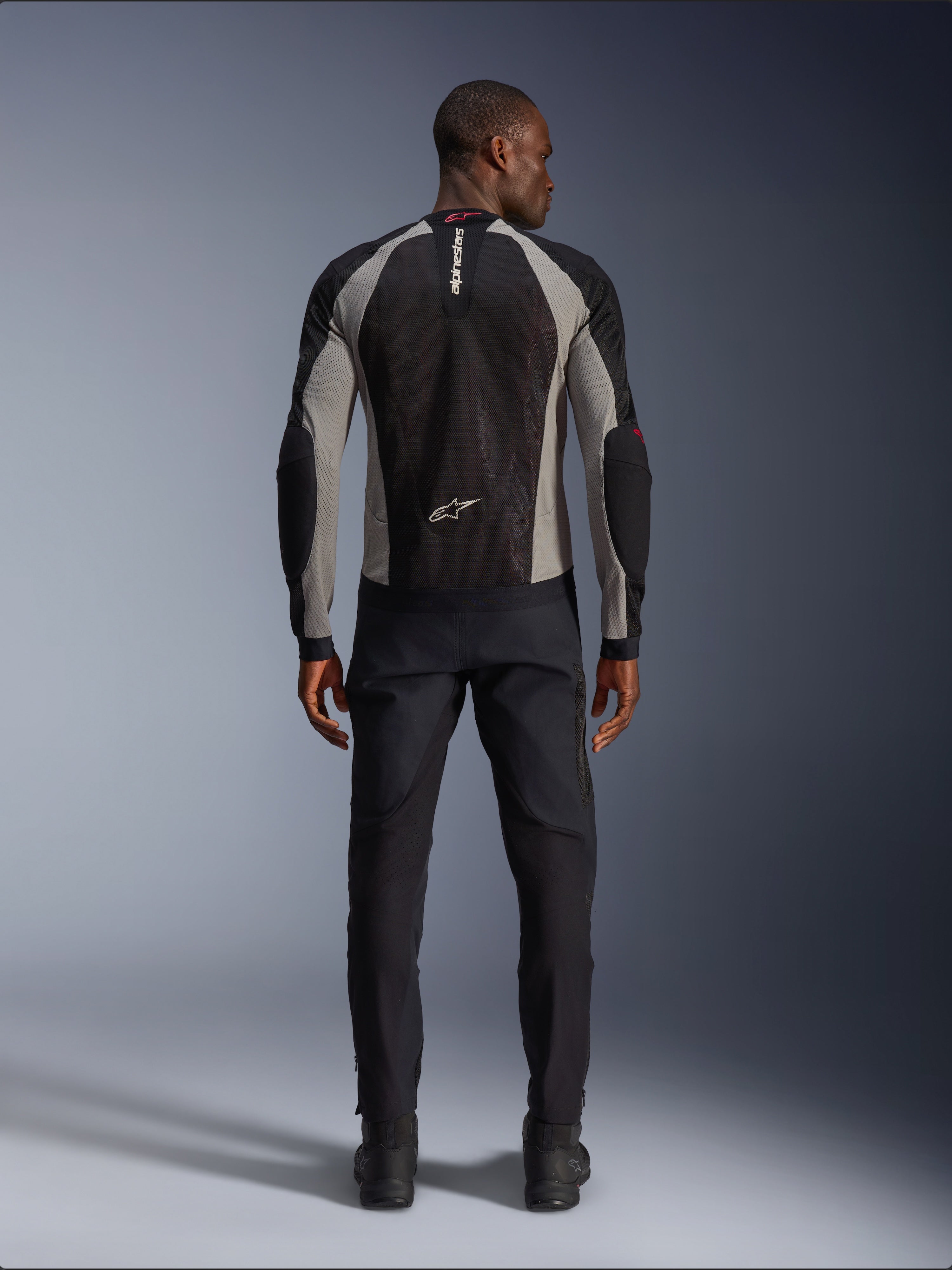 Alpinestars Troop-Air Jacket, Black Ash Gray and Bright Red motorcycle jacket, rear view on male model, lightweight mesh construction for ventilation, Alpinestars branding on collar and lower back, paired with black riding pants