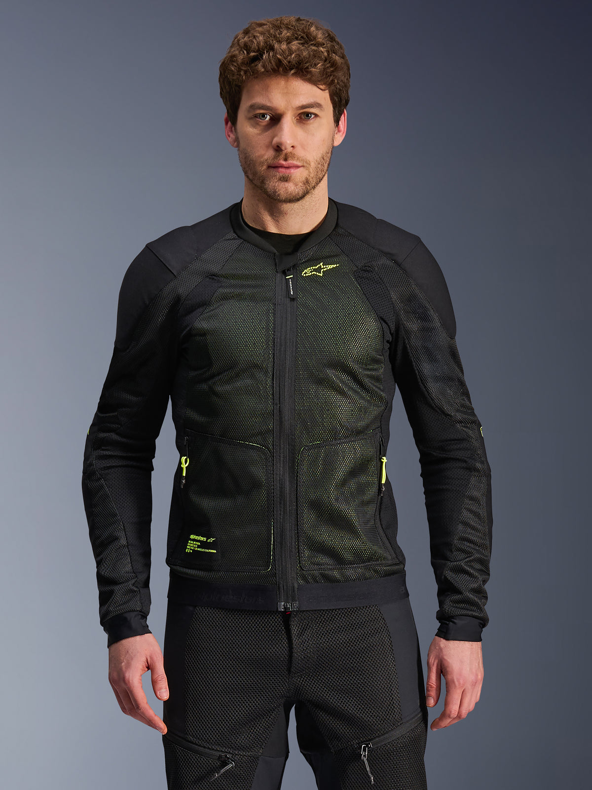 Alpinestars Troop-Air jakke, sort og gul fluo, bæres af mandlig model, letvægts mesh-konstruktion, neongule lynlåse og branding, teknisk ventileret motorcykeljakke til urban kørsel