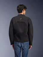 Alpinestars Provoke-jakke, urban motorcykeljakke, sort, set bagfra med hvidt Astars-logo og tekniske ripstop-paneler, båret med blå denimjeans, moderne design til pendling i byen