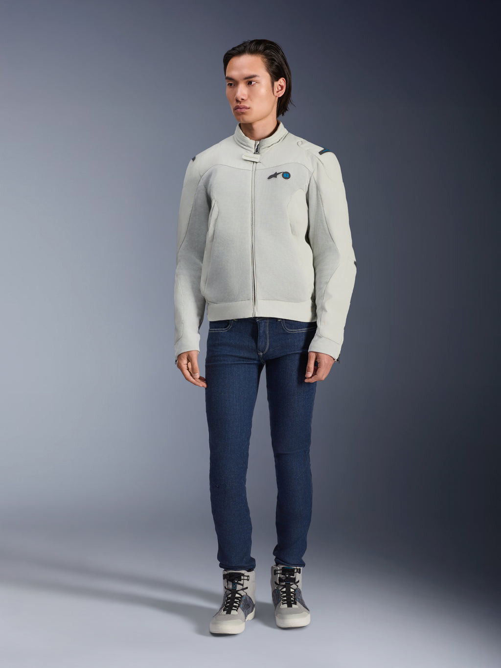 Alpinestars Circal-1 Air-jakke, Metal Gray, urban motorcykeljakke med mesh-paneler til luftgennemstrømning, båret af en model med blå jeans og grå kørselssneakers, minimalistisk design til bæredygtig bykørsel.