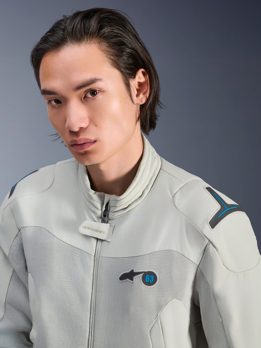 Alpinestars Circal-1 Air-jakke, Metal Gray med Methyl Blue-detaljer, mandlig model iført urban sommer-motorcykeljakke, nærbillede af mesh-ventilationspaneler og minimalistisk branding på brystet