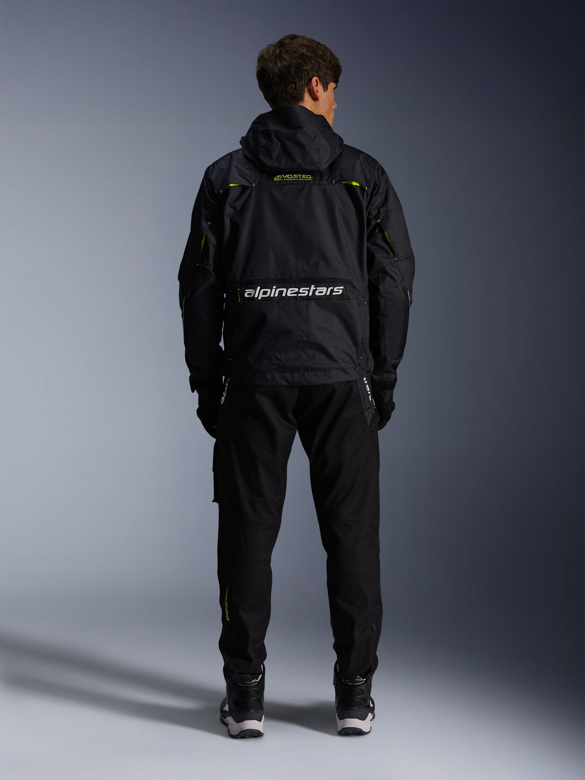 Alpinestars Mogress Air Jakke, sort og lime punch urban motorcykeljakke i tekstil, set bagfra med hvid branding.