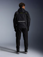 Alpinestars Mogress Air-jakke, urban motorcykeljakke, set bagfra i sort med lime punch og hvide detaljer, med Alpinestars-branding på tværs af den nedre del af ryggen, båret med sorte bukser og støvler.