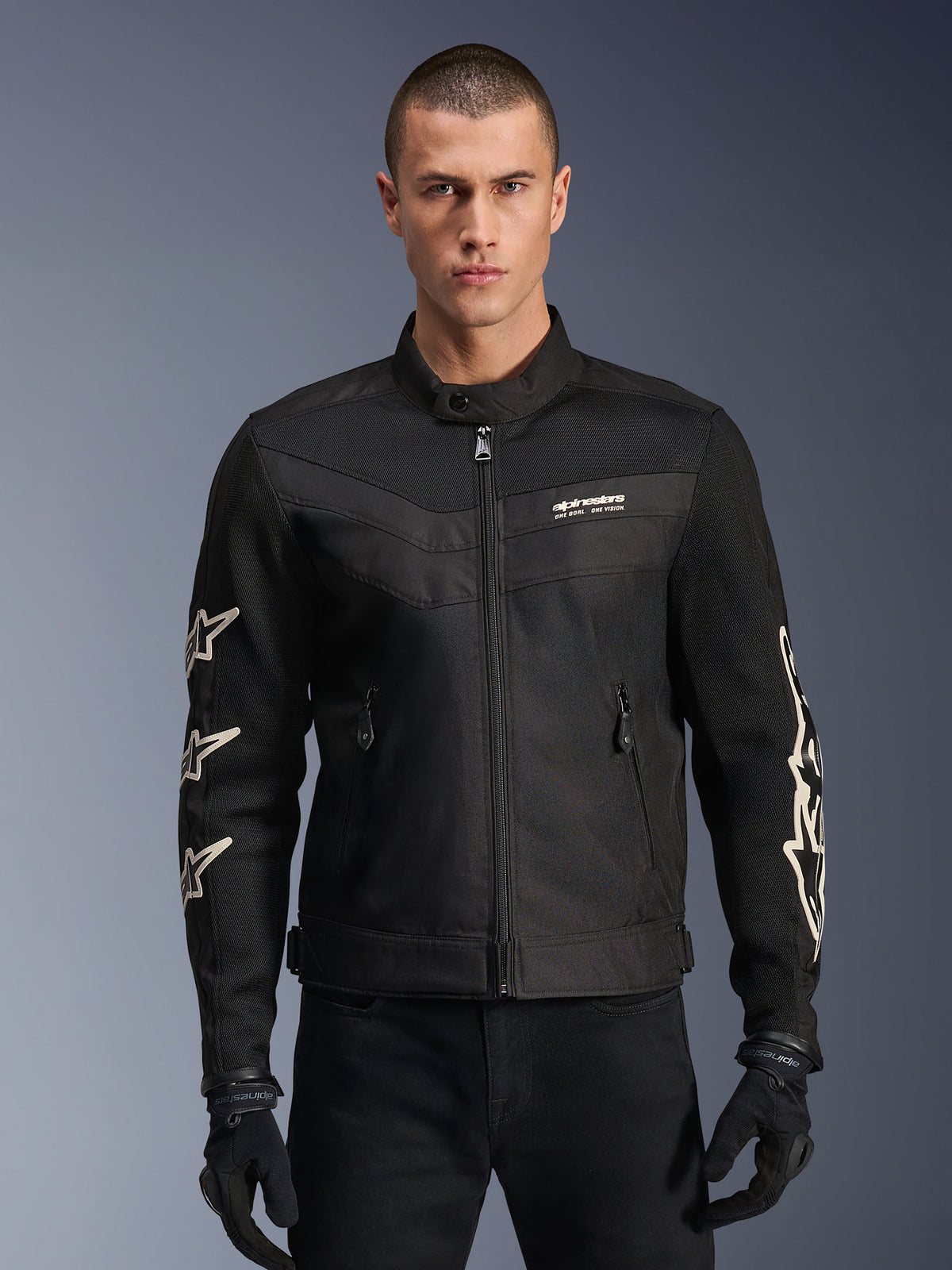 Alpinestars T-Dyno Air Jacket, Black textile motorcycle jacket, featuring white star graphics on sleeves and logo on chest, mesh panels for ventilation, vintage-inspired biker fit, worn with black gloves and pants