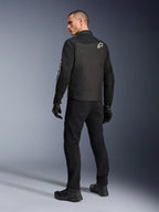 Alpinestars T-Dyno Air-jakke, sort, set bagfra af model iført en åndbar tekstil-motorcykeljakke, med hvidt Alpinestars-logo på skulderen, kombineret med sorte bukser og handsker, urban kørestil