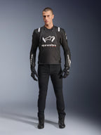 Alpinestars T-Stunt Air Jacket, sort og hvid motorcykeljakke, båret med sorte kørebukser, handsker og støvler, med markant hvidt Alpinestars-branding på brystet og ærmerne, sport-cut tekstildesign med mesh-paneler til ventilation